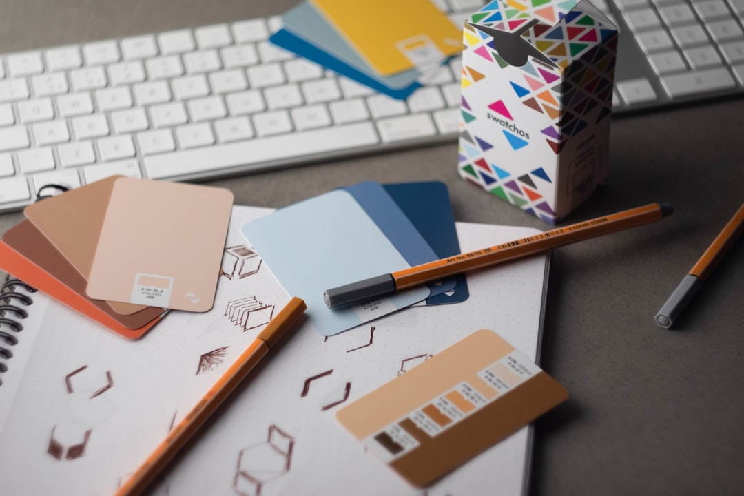 Swatchos color swatch cards with CMYK and RGB hex values showing being used by a graphic designer on a graphic designers desk